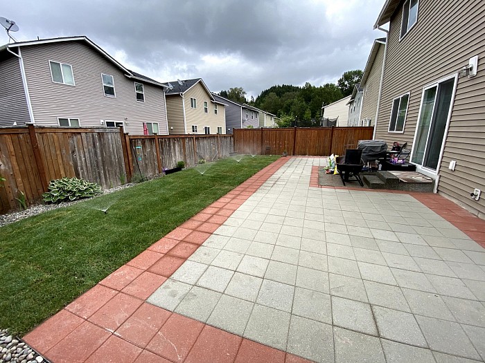 Paver patio, new sod and river rock along the fence